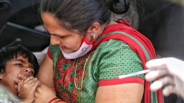 A mother and child get their sample taken at a RT PCR testing facility in Ahmedabad in April 2021 | Praveen Jain | ThePrint