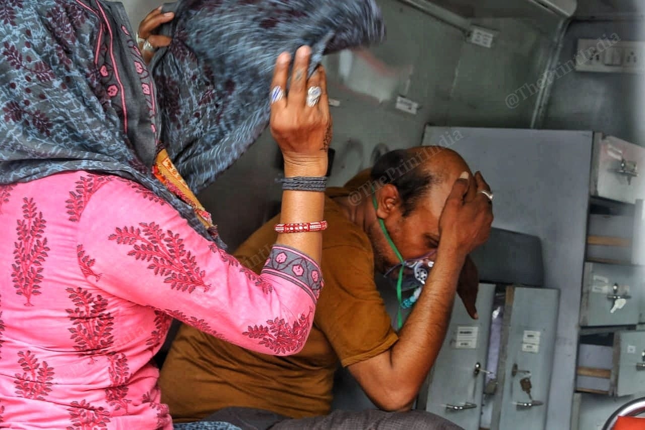 A covid positive patient's family consoles him as he gasps for breath | Photo: Praveen Jain | ThePrint
