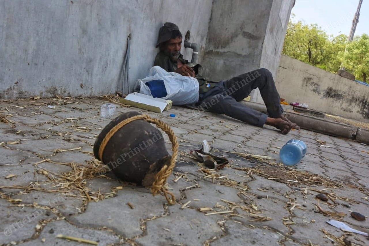A man exhausted by the wait, lays down with the puja material for the vidhi | Photo: Praveen Jain | ThePrint