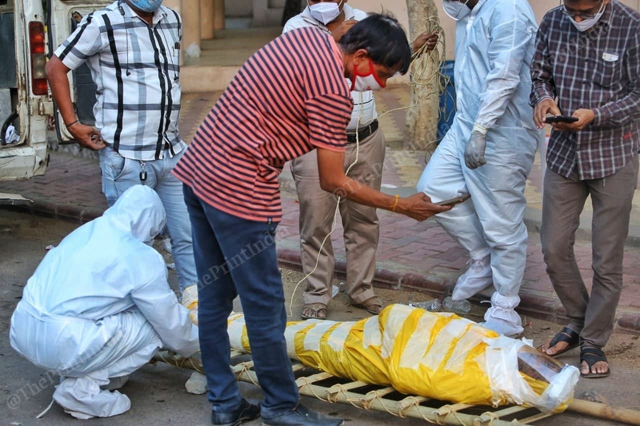 The last memory, a man clicks pictures if his father before he is cremated in Ellisbridge | Photo: Praveen Jain | ThePrint