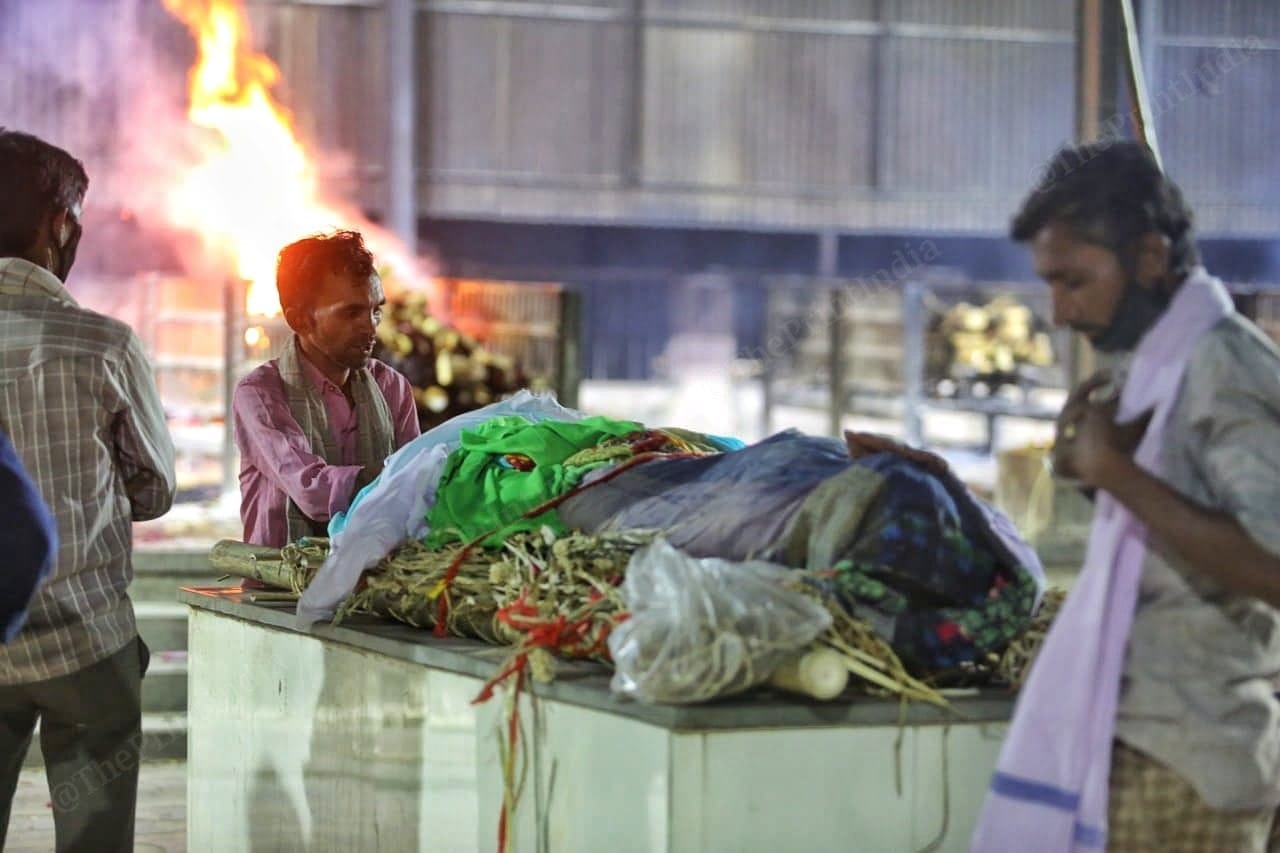 The last prayer, a son prays infornt of his fathers body while waiting for him to be cremated | Photo: Praveen Jain | ThePrint