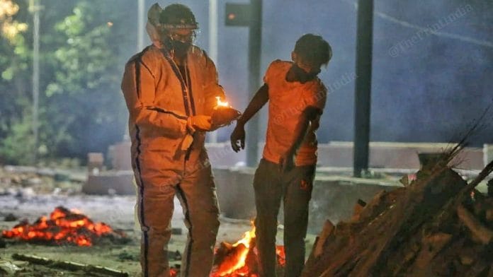 Ambulance staffer Ankur Singh helps a Delhi journalist cremate his mother, who died of Covid, in Noida Tuesday | Praveen Jain | ThePrint