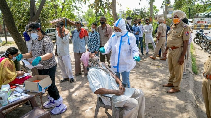 A health worker take nasal sample of commuters for Covid-19 test, amid rise in coronavirus cases across country, in Jalandhar, Tuesday April 13,2021. | PTI