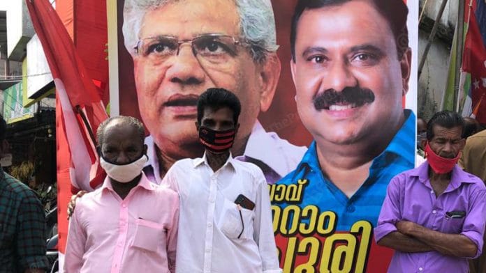 Voters in Peyyad Junction in Thiruvananthapuram stand in front of a hoarding of CPM general secretary Sitaram Yechury and CPM candidate I B Satheesh | Photo: Jyoti Malhotra | ThePrint