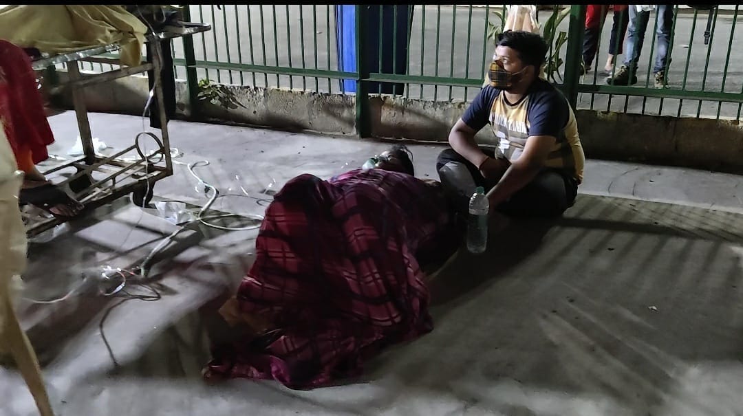 A man tries to comfort his mother having breathing troubles at GTB Hospital | Shubhangi Misra | ThePrint