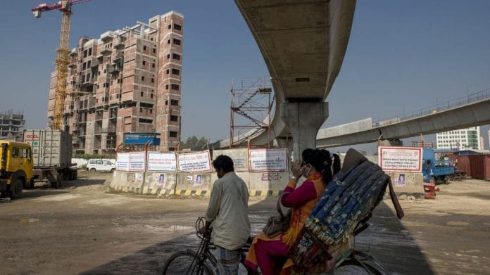 A rickshaw travels past an under construction elevated line for the Dhaka Mass Rapid Transit Co. metro in Diabari, Dhaka, Bangladesh | Photographer: Ismail Ferdous | Bloomberg