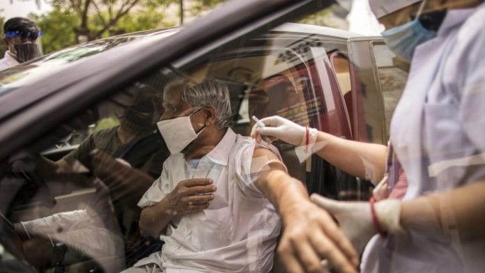 A person receives a dose of Covid-19 vaccine at a drive-thru vaccination site set up at the DLF Mall of India in Noida, UP | Photographer: Anindito Mukherjee | Bloomberg