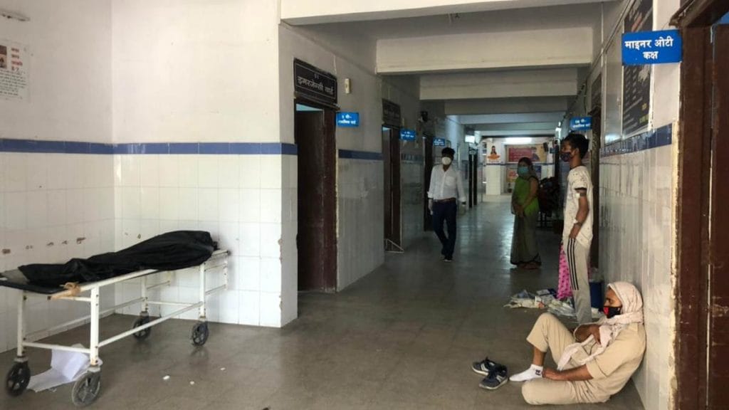 An attendant waits for an ambulance to take the body of a patient for cremation, at Sadar Hospital in Buxar | VK Global Hospital, a private Covid facility in Buxar, charges Rs 150/hour for oxygen from patients | Photo: Jyoti Yadav | ThePrint