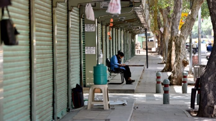 A security guard outside a closed shop in Janpath Market during the lockdown in New Delhi, on 24 May 2021