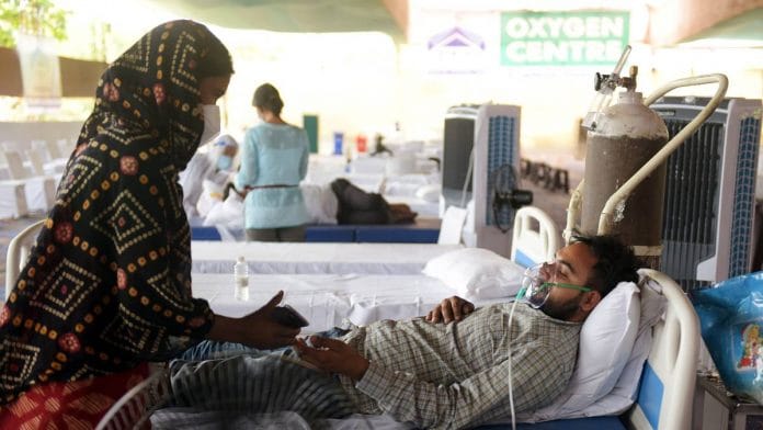 A Covid-19 patient breathes with the support of an oxygen cylinder provided by an NGO, in Gurugram on 14 May 2021 | ANI