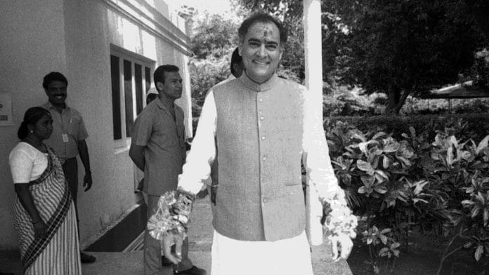 A smiling former PM Rajiv Gandhi displays his collection of rakhis