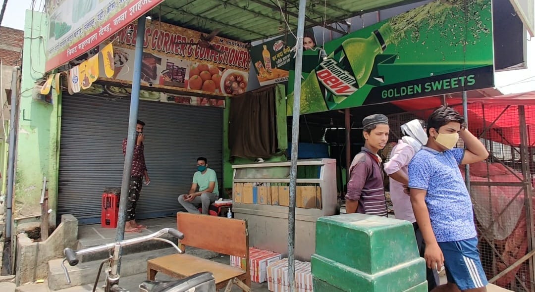 Zakir (in light green t-shirt) seated outside a shop, which is closed on account of the weekend lockdown in UP | Urjita Bhardwaj | ThePrint