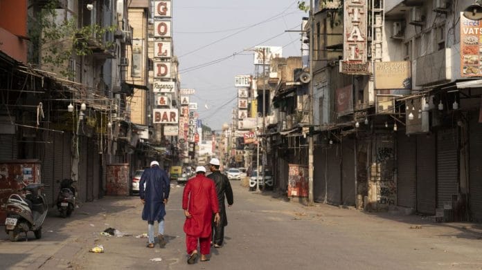 Pedestrians walk past closed hotels and stores during lockdown restrictions imposed by the state government in the Paharganj area of New Delhi, on 14 May 2021 | Photographer: Sumit Dayal | Bloomberg