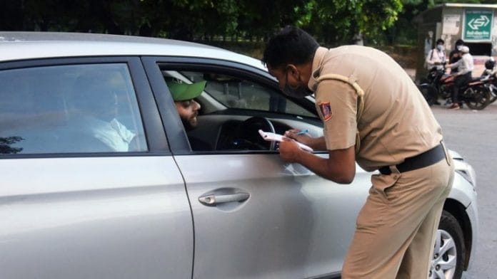 A police personnel stops an individual not wearing a mask while driving | Photo: ANI