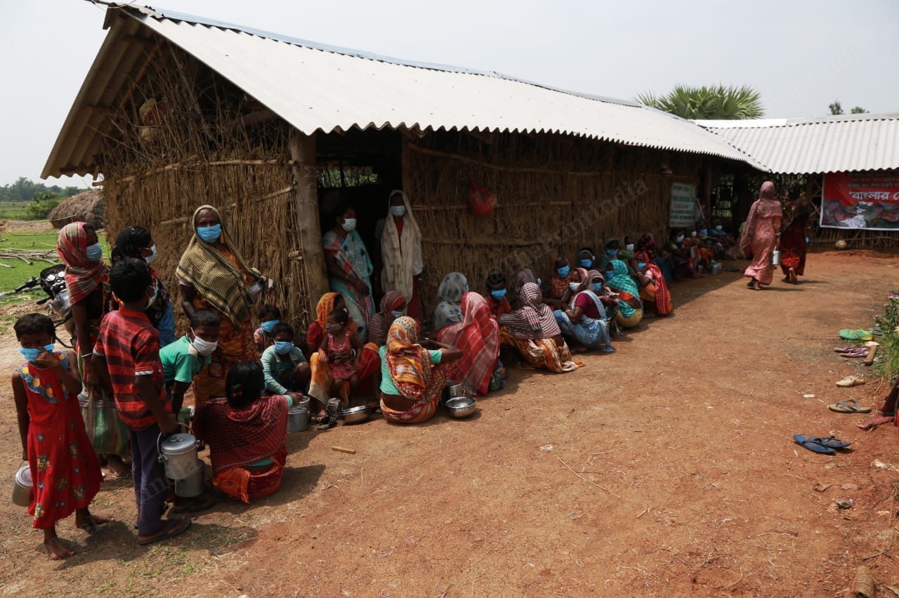The country side has scorching sun as well as humidity. The women sit in the shade of the hut while waiting for food distribution | Photo: Manisha Mondal | ThePrint