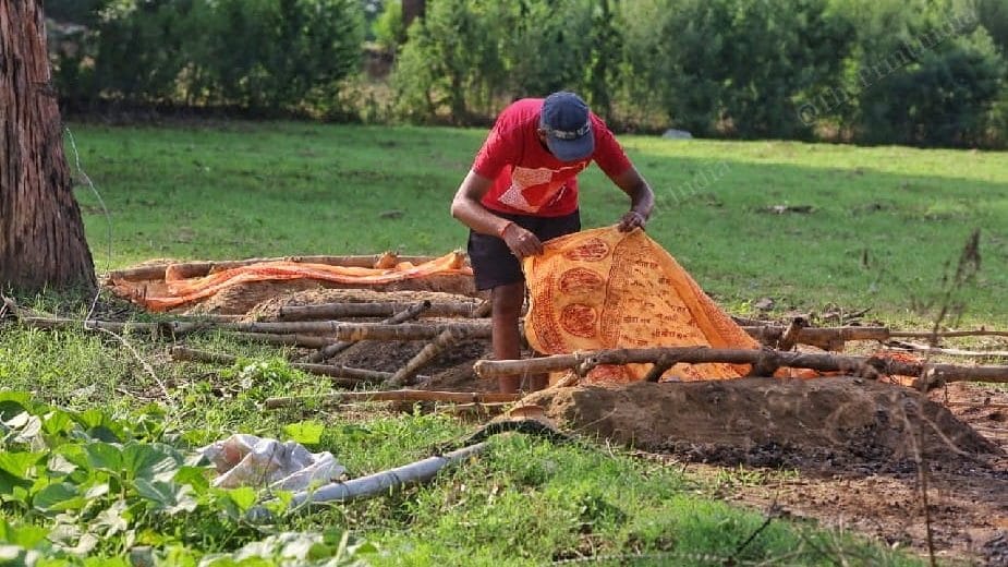 Karan Yadav, son of Nirankar Yadav, places a ritual shroud at his father's samadhi | Photo: Praveen Jain/ThePrint