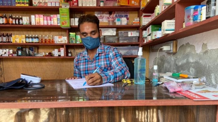 Jagdesh, a registered medical practitioner at Patiala's Bolar Kalan village. notes down details of patients who visit him with Covid-like symptoms | Reeti Agarwal | ThePrint