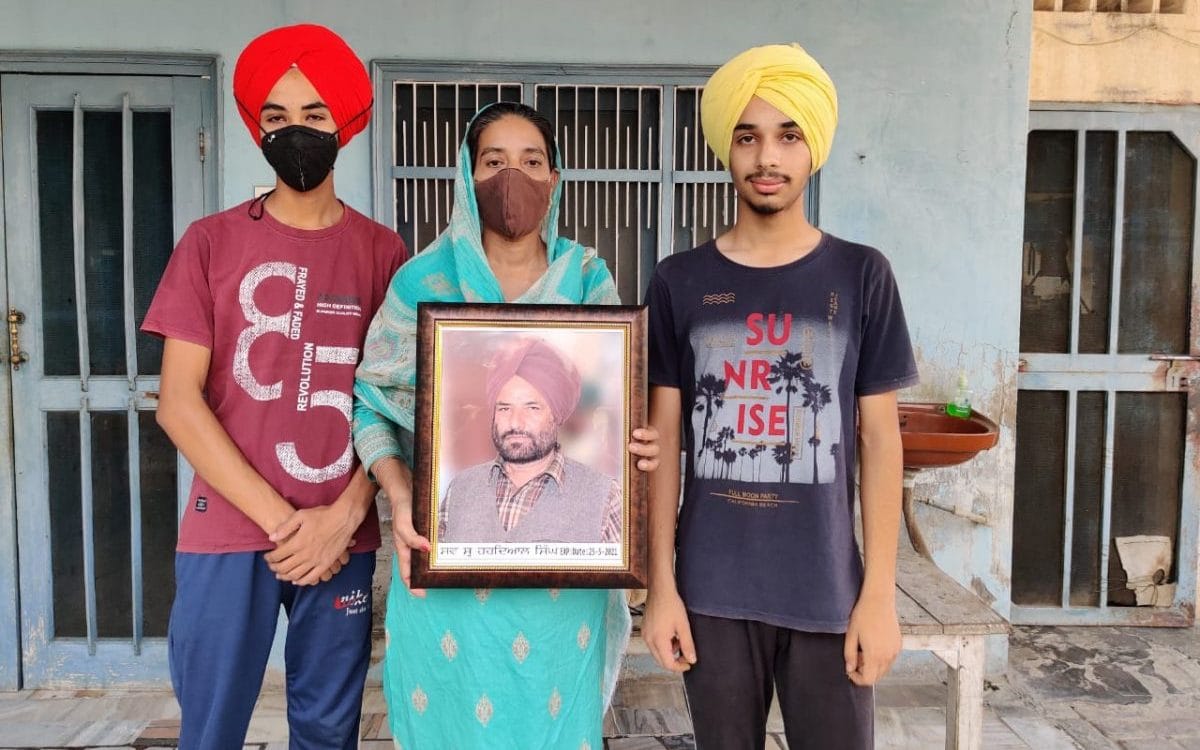 Singh’s wife Kulwinder Kaur with their twin sons Damanpreet Singh (left) and Dilpreet Singh. Kaur holds a photograph of her husband | Photo: Reeti Agarwal/ThePrint