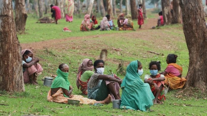 Tribal women sit under the Sal wood trees with their lunch boxes | Photo: Manisha Mondal | ThePrint