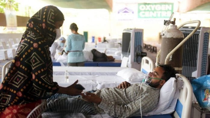 A Covid-19 patient breathes with the support of an oxygen cylinder provided by an NGO, in Gurugram on 14 May 2021 | ANI