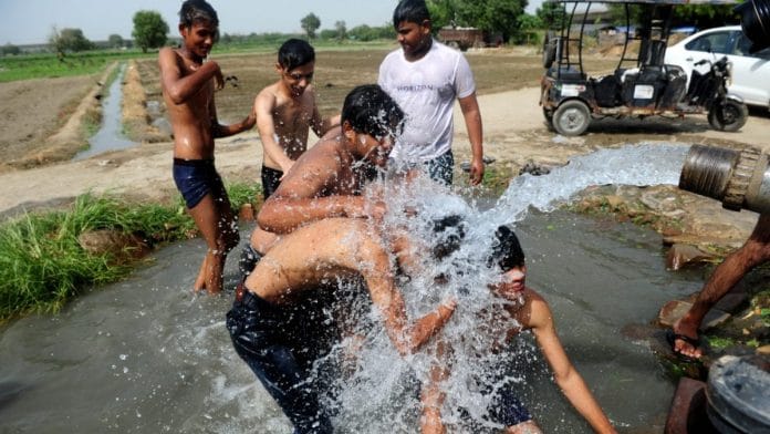 Local residents in East Delhi’s Trilokpuri seek relief at a tubewell amid the heatwave in Delhi | Photo: Suraj Singh Bisht/ThePrint