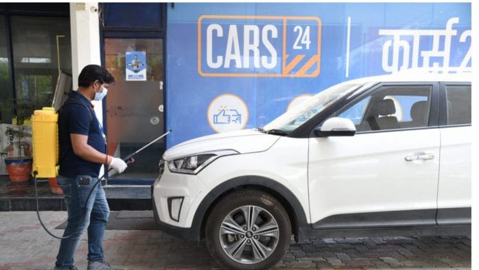 A Cars24 employee sanitises a used car | cars24.com