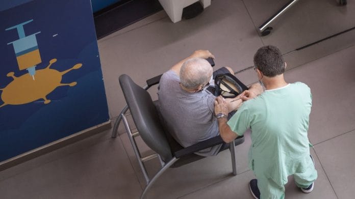 A health worker administers a third dose of the Pfizer-BioNTech Covid-19 vaccine to an elderly resident in Tel Aviv, Israel, on 2 August 2021 | Bloomberg