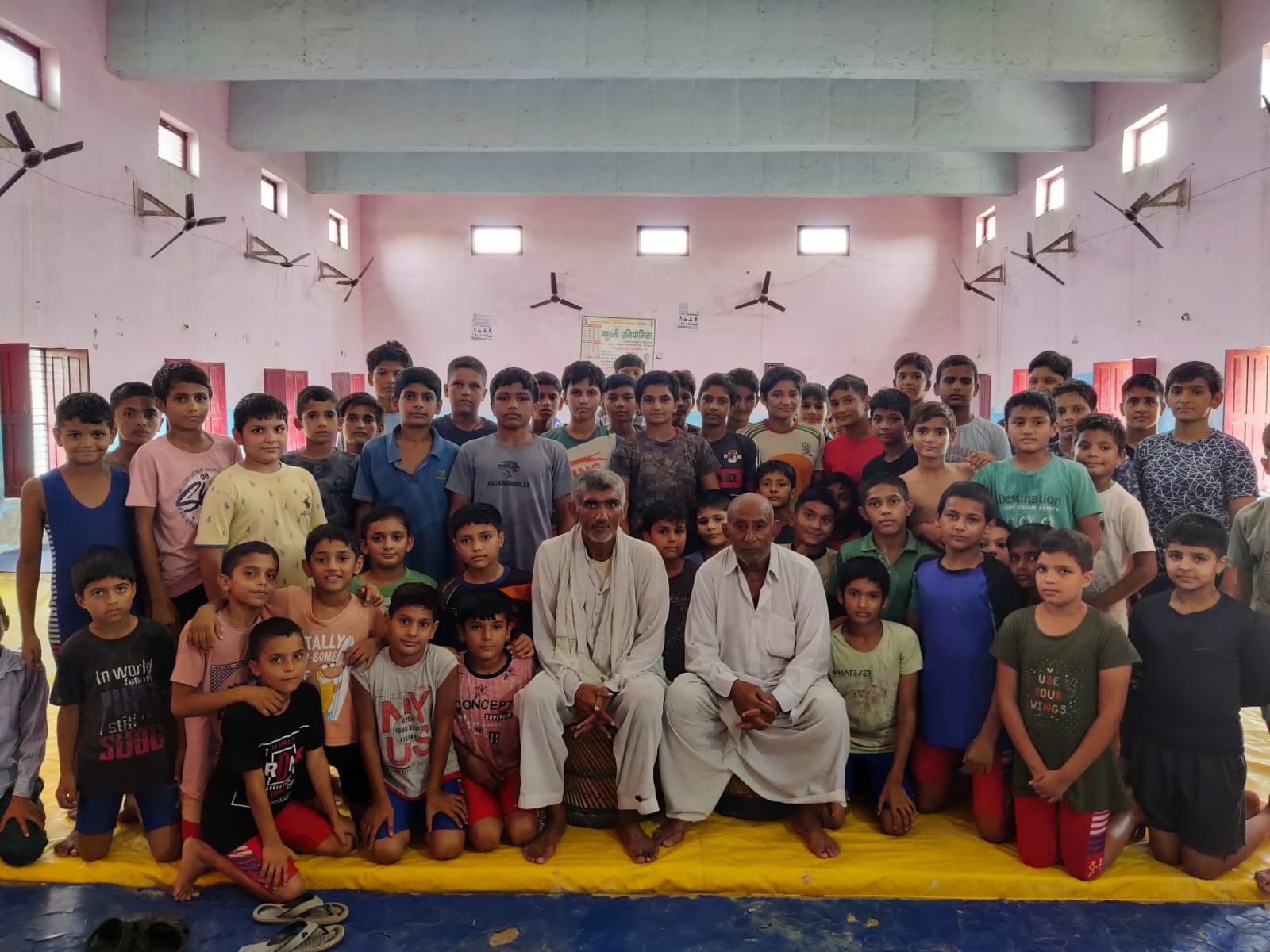 Students at Shankar Vyayamshala pose with their coaches Satpal (60) and Maaria in Haryana's Nokhra village in Rohtak | Photo: Shubhangi Misra/ ThePrint