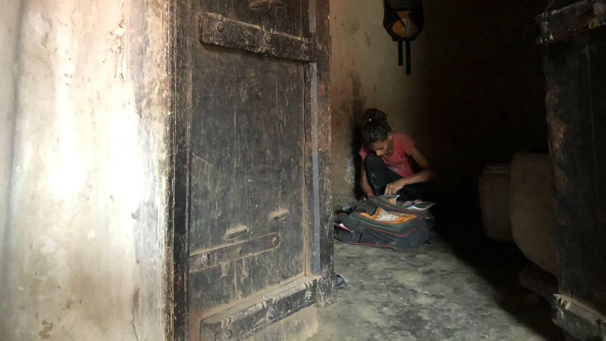 Sapna puts the money she got from selling her MDM ration in her school bag | Jyoti Yadav | ThePrint