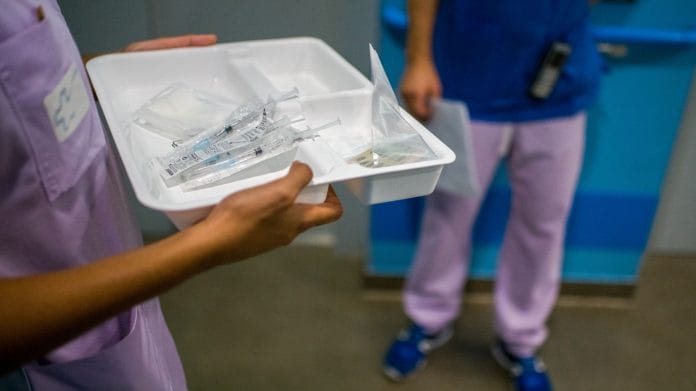 Healthcare workers prepare third doses of Pfizer Covid-19 vaccine at a senior-living facility in Paris on 16 September 2021 | Photo: Nathan Laine | Bloomberg