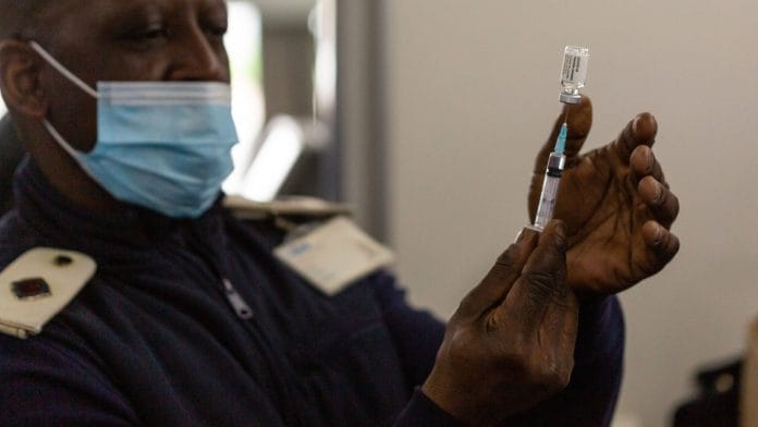 A health worker prepares a dose of Covid-19 vaccine onboard a pop-up vaccination bus on 26 August 2021. Photographer: Dwayne Senior/Bloomberg