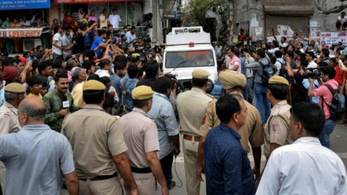 An ambulance carries away the bodies of the 11 members who were found hanging from an iron grill in a house, in Burari, July 2018 | PTI