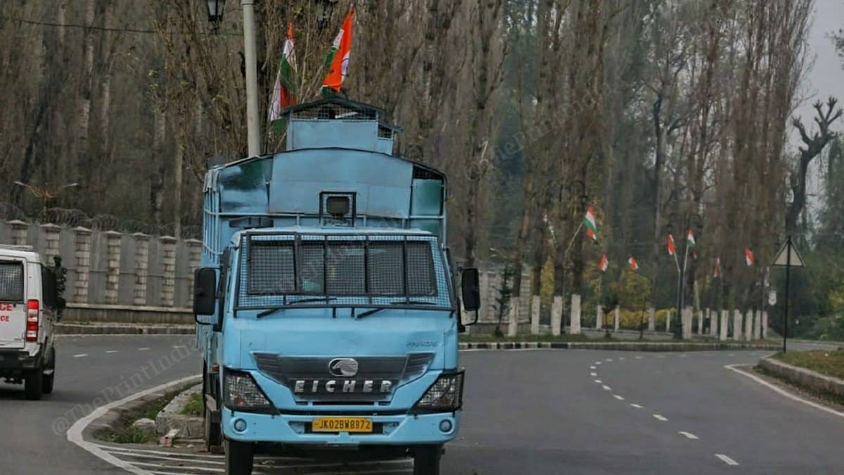 A police van drives through a deserted road. | [Photo: Praveen Jain | ThePrint