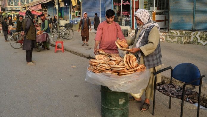 A baker sells bread along a road in Kunduz , Afghanistan on 10 October 2021