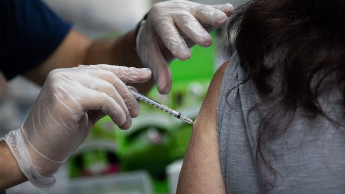 A pharmacist administers a third dose of the Moderna Covid-19 vaccine in Michigan, US