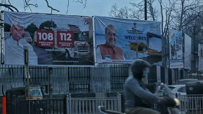 A man rides by a banner welcoming Amit Shah. | Photo: Praveen Jain | ThePrint