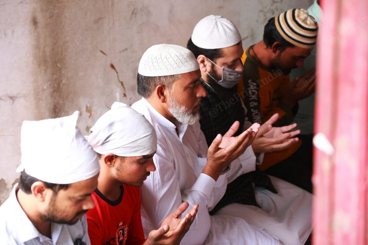 Workers offer prayer inside the shop | Photo: Manisha Mondal | ThePrint