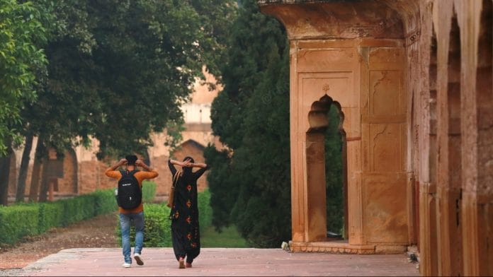 At Safdarjung Tomb a couple walk past the monument | Photo: Manisha Mondal | ThePrint