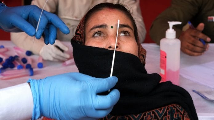 A medical worker collects sample for Covid-19 testing | Bloomberg