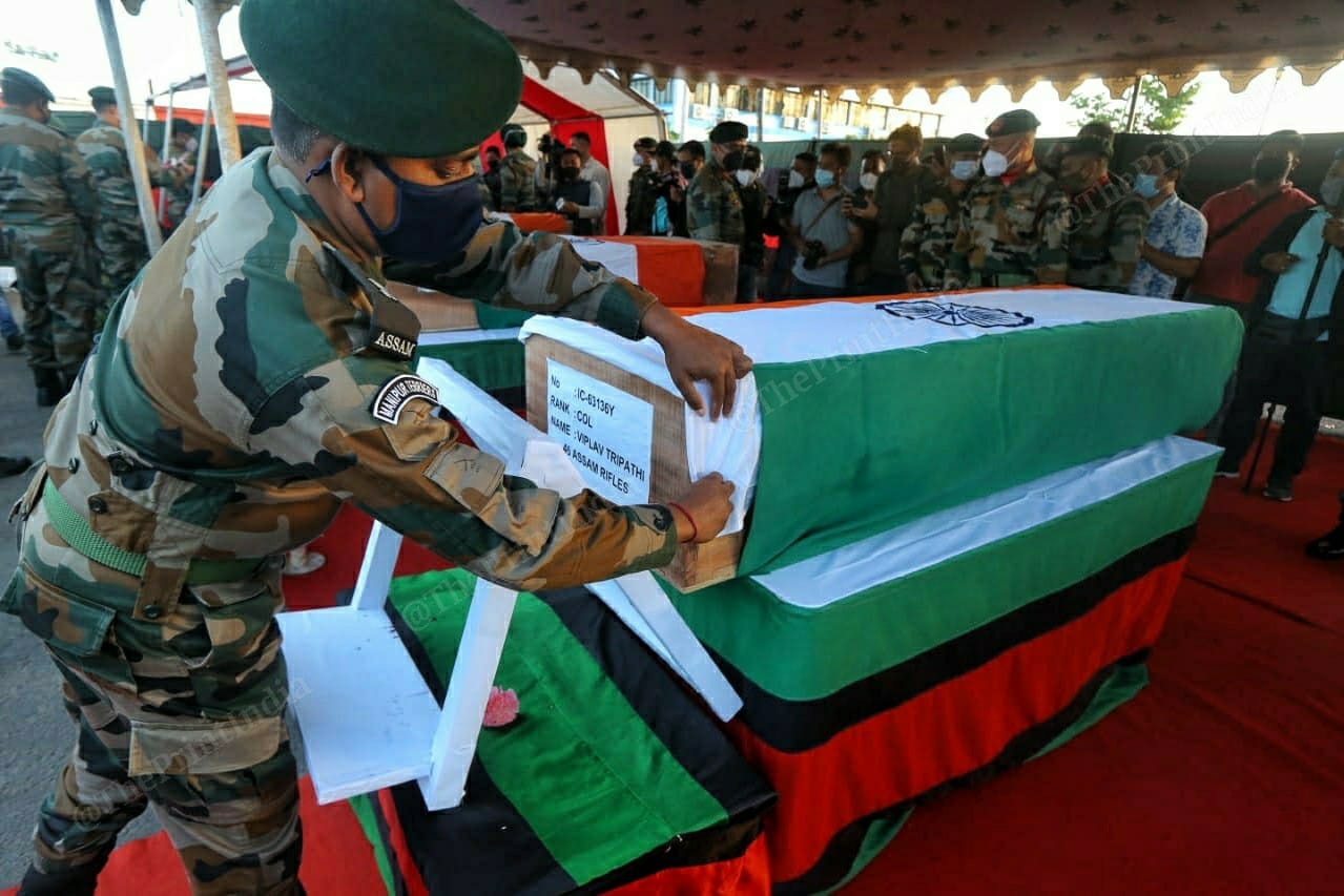 A soldier covers CO Tripathi's coffin with a flag | Photo: Praveen Jain | ThePrint