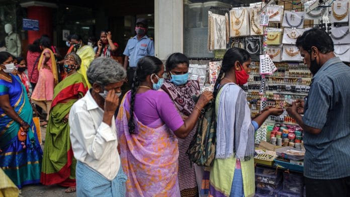 Customers wearing protective masks at a jewellery store in Chennai | Bloomberg