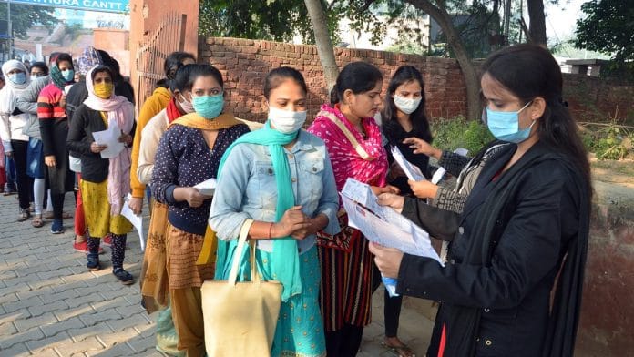 Aspirants get their documents verified by an invigilator as they appear for the Uttar Pradesh Teacher Eligibility Test 2021 at an examination centre, in Mathura on 28 November 2021. | Photo: ANI