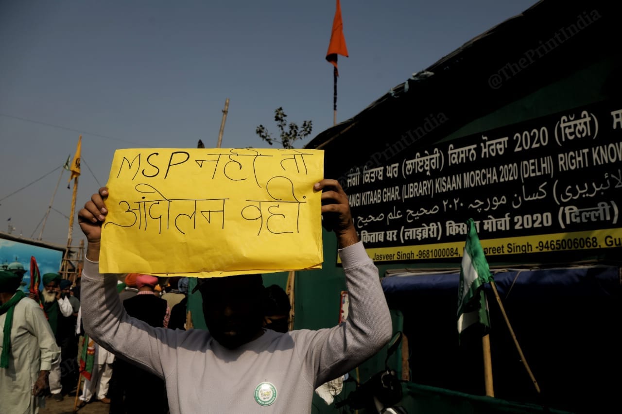 A protester holding up a banner seeking legal guarantee for MSP, at the Singhu border on 26 November 2021. | Photo: Manisha Mondal/ThePrint