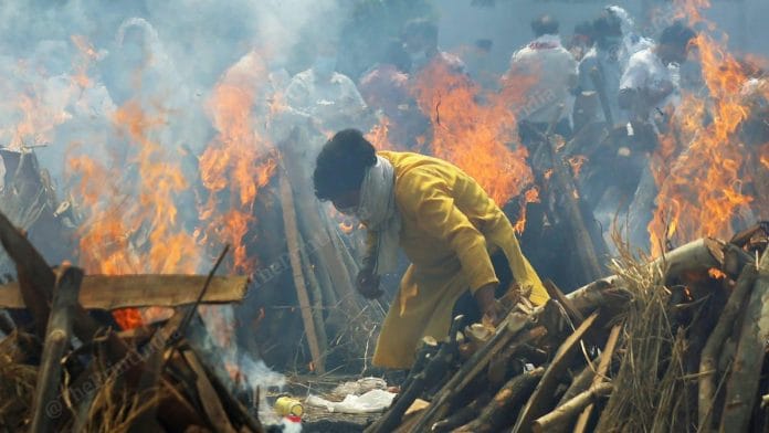 During the second wave of covid, a man burns the pyre at Seemapuri crematorium | Photo: Suraj Singh Bisht | ThePrint
