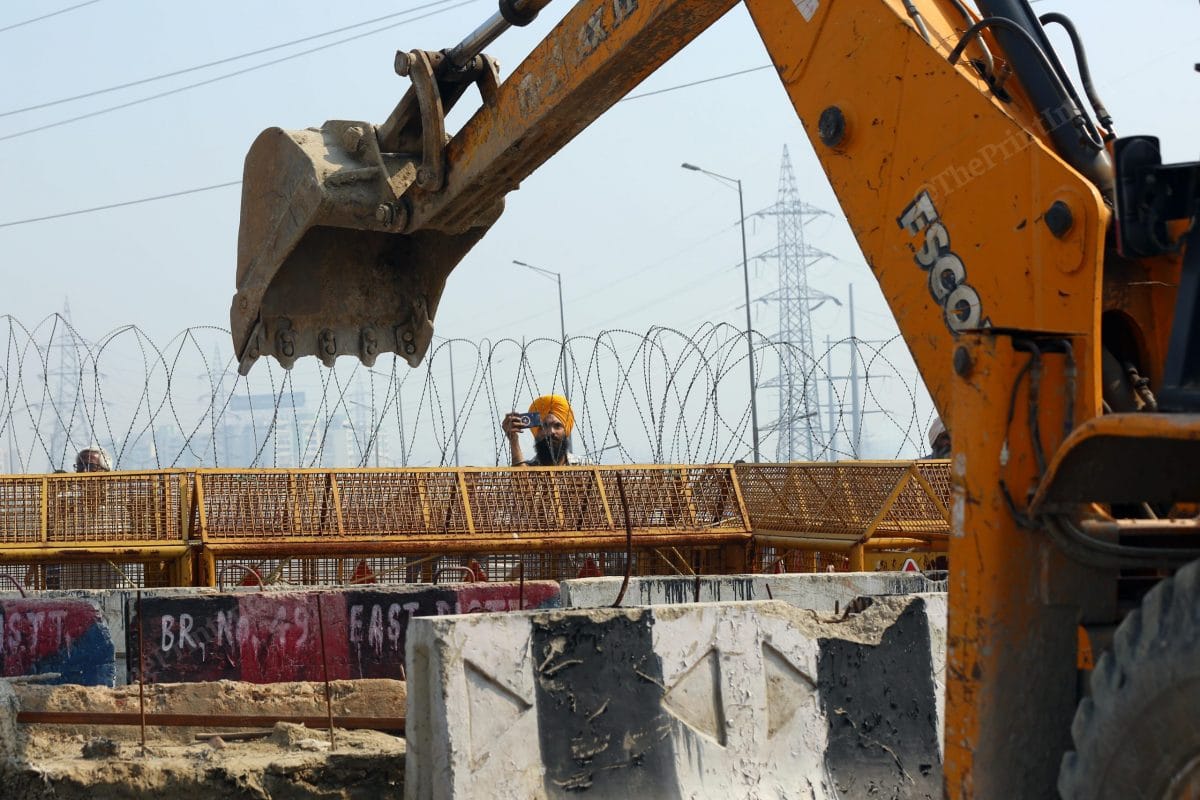 A farmer takes videos while the police removes the barricades after the Modi government agreed to the demands of the farmers and took back the three farm laws | Photo: Suraj Singh Bisht | ThePrint