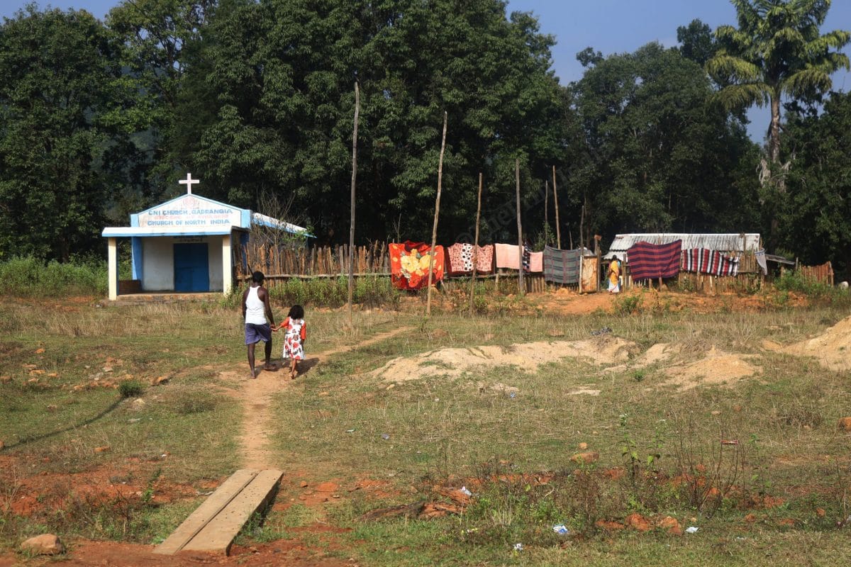 Hiroz Nayak, the 37 years old who had witnessed riots in 2008 walks with his daughter towards their home. Nayak, his family along with other Christian neighbours had fled where rioters attacked | Photo: Manisha Mondal | ThePrint 