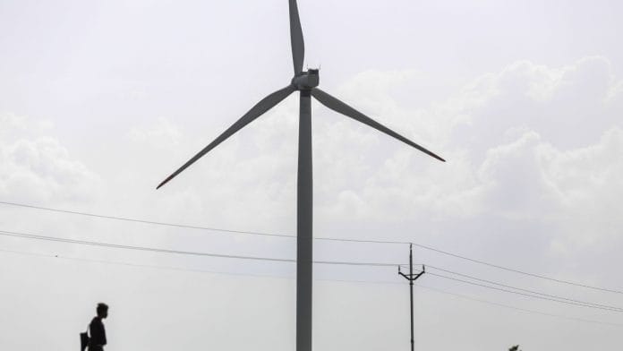 A man grazes a herd of goats near a wind turbine manufactured by Inox Wind Ltd. in Lahori, Madhya Pradesh | Representational image | Bloomberg