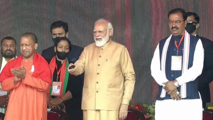 Prime Minister Narendra Modi with UP Chief Minister Yogi Adityanath and deputy CM Keshav Prasad Maurya, at the launch of women-centric initiatives in Prayagraj, on 21 December 2021 | PTI Photo