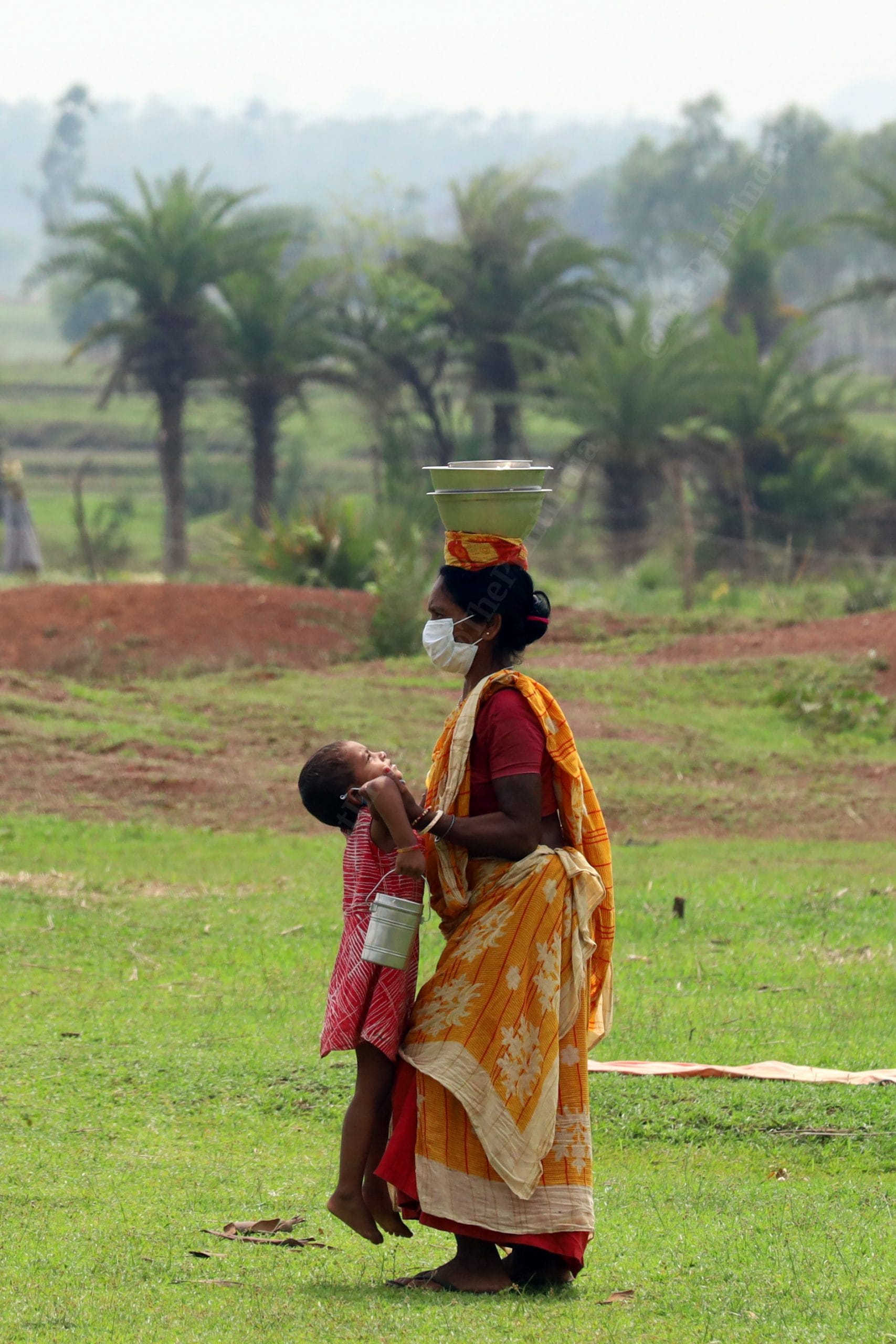 A woman carries bowl of food on her head. A community kitchen in a tribal village in West Bengal has been providing food to tribals and migrant workers in the area in the month of June | Photo: Manisha Mondal | ThePrint