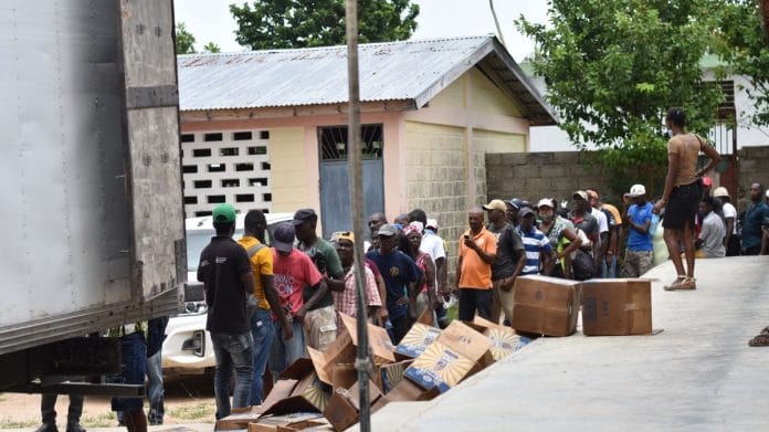 Residents wait in line to receive bags of rice and cooking oil at a World Food Programme distribution site in Port-Salut, Haiti | Bloomberg